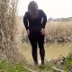 A girl squats in front of a pond in a swampy landscape and takes a loose shit. Her poop is shown on the ground, and then she wipes her ass. About 3 minutes.